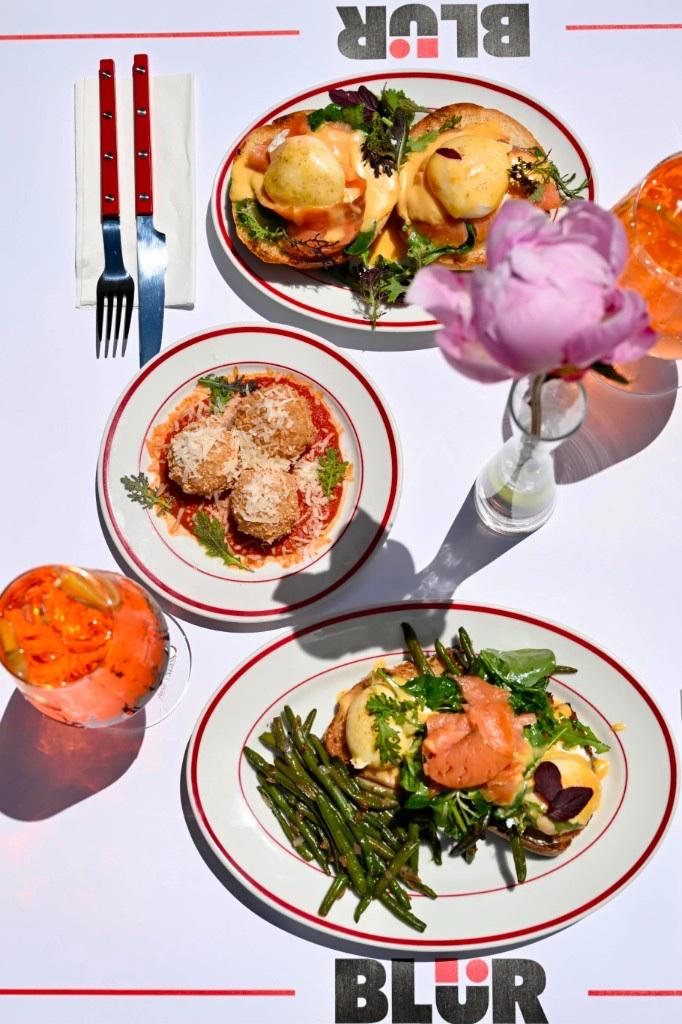 Masă plină de brunch: ouă benedict, arancini, somon, spritz