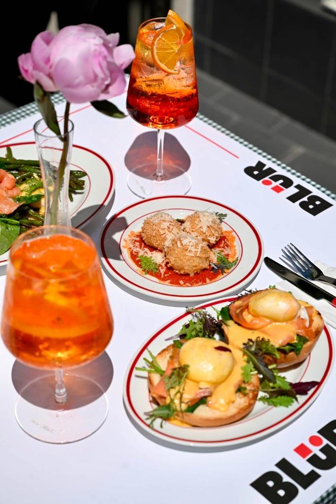 Detaliu de masă la BLÜR: bujor, spritz, arancini și ouă benedict