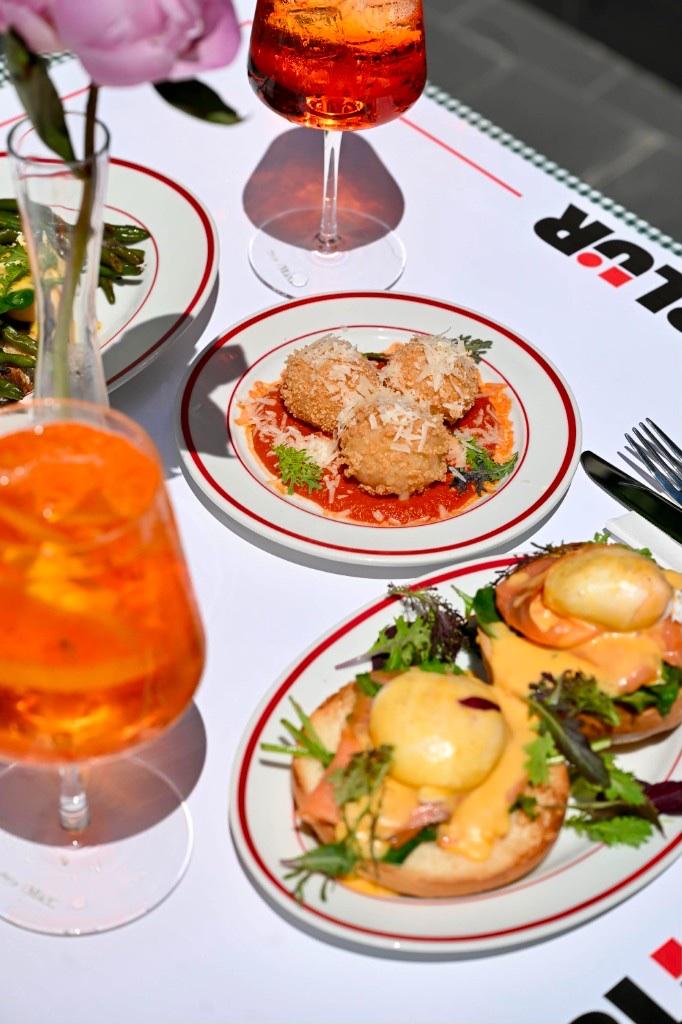 Spritz cu felie de portocală lângă farfurii de brunch